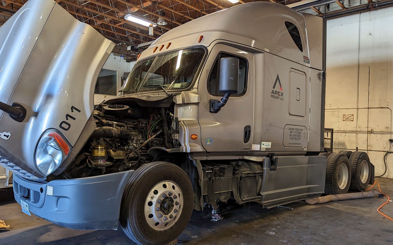 Semi truck with the hood open inside the Emerald Fleet Services shop in Sumner, WA